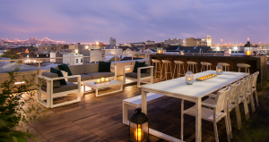 A rooftop view of the city from The Beacon's fourth floor terrace with tables and bar surrounded by chairs.