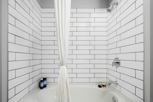 White subway tiled shower, sleek, minimalist aesthetic. bathroom at The Beacon at South Market in New Orleans.