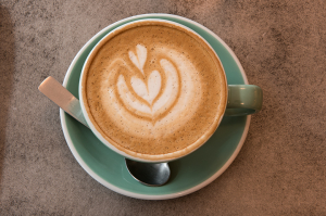 A cub of a latte with a heart shaped foam design