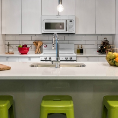 Kitchen island with three stools and a subway tile back splash
